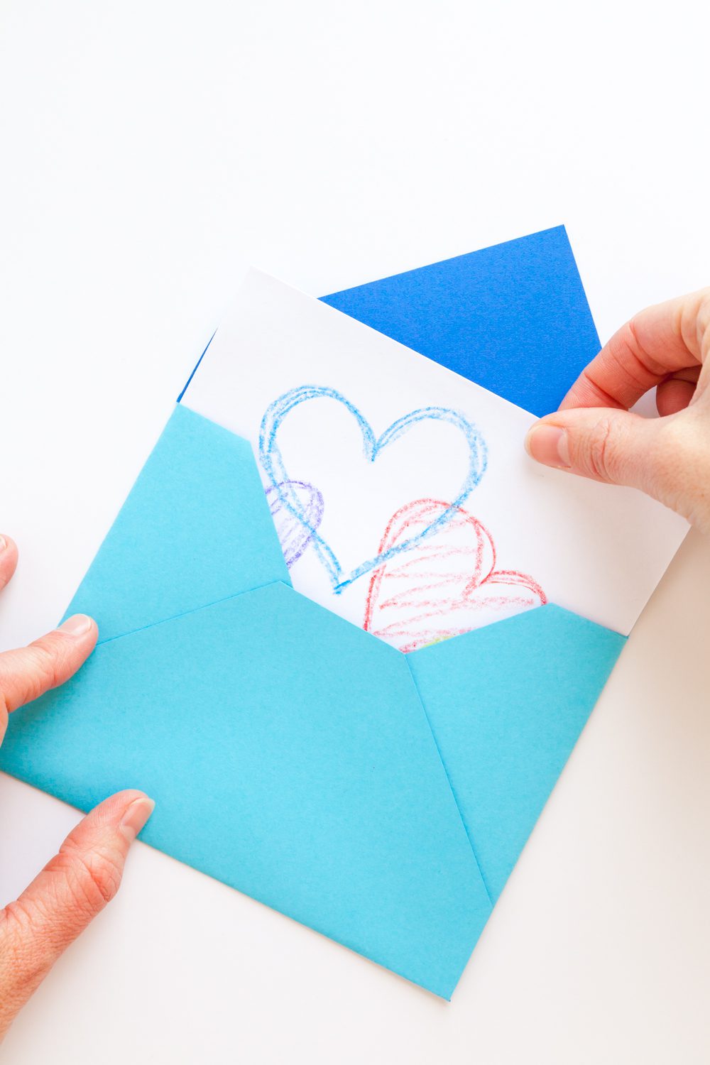 Pulling a card with hearts from a blue handmade traditional envelope.