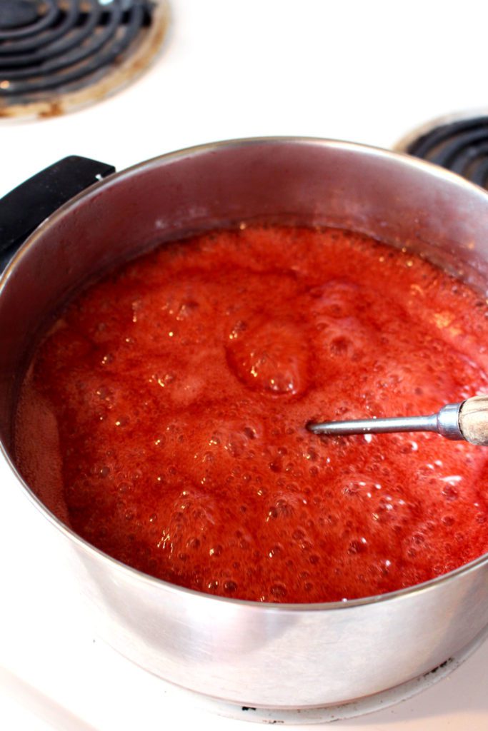 A large pan of boiling red fruit puree.