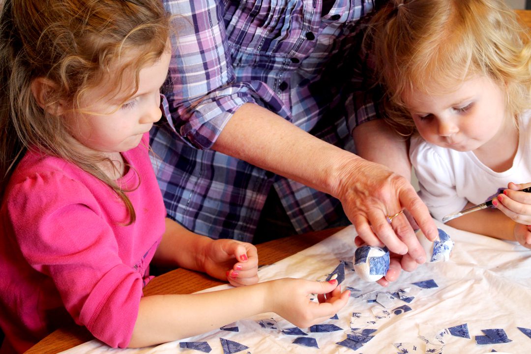 Children using decoupage to decorate easter eggs.