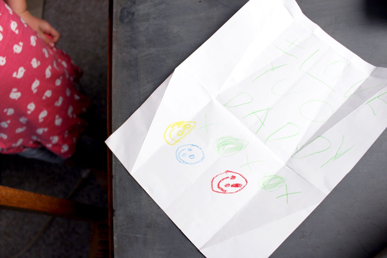 A folded piece of paper opened to show a child's drawing.