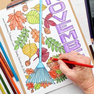 Completed November coloring page near colorful leaves and colored pencils.