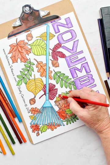 Completed November coloring page near colorful leaves and colored pencils.