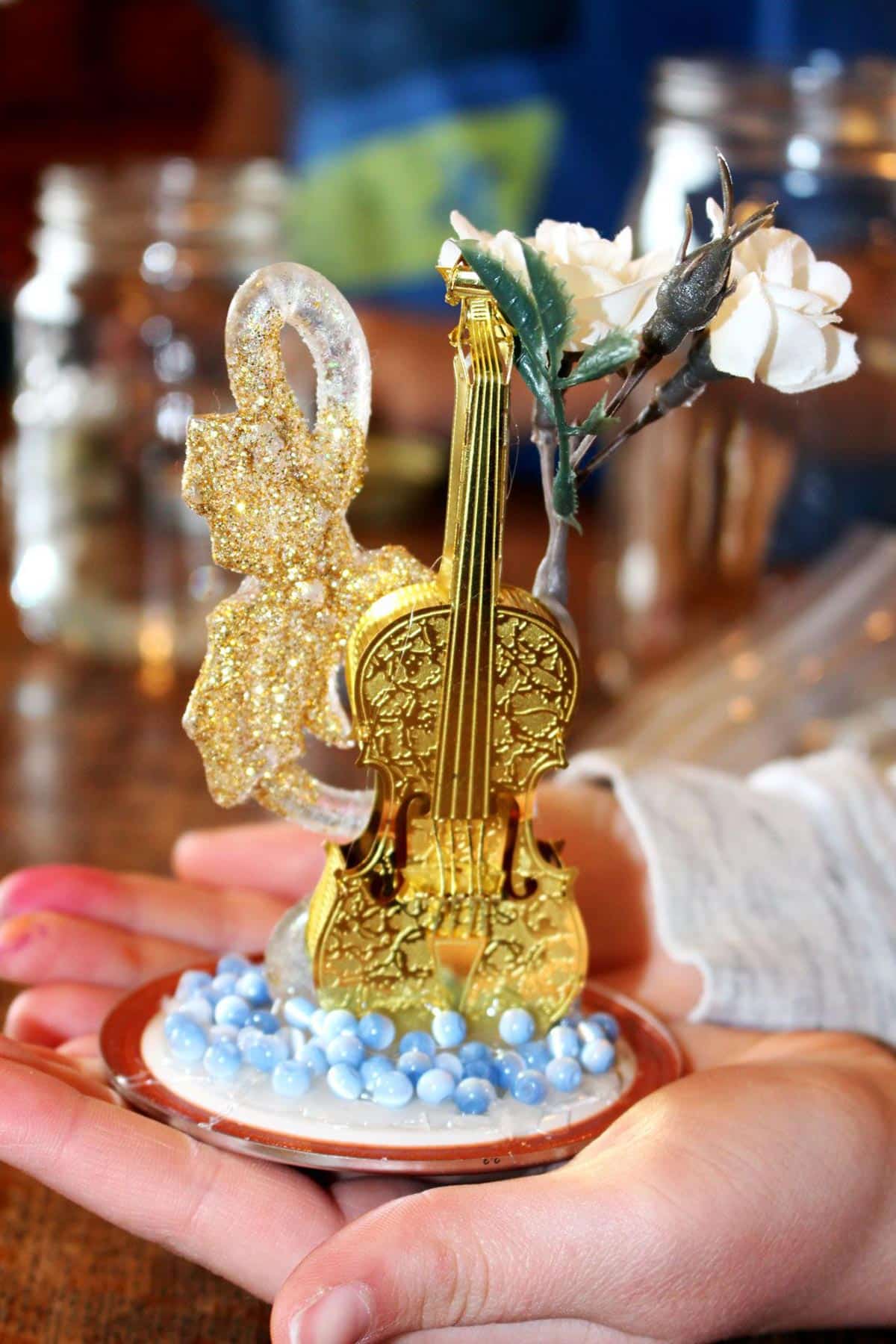 Two ornaments and plastic flowers glued to a mason jar lid as the centerpiece for the snow globe.