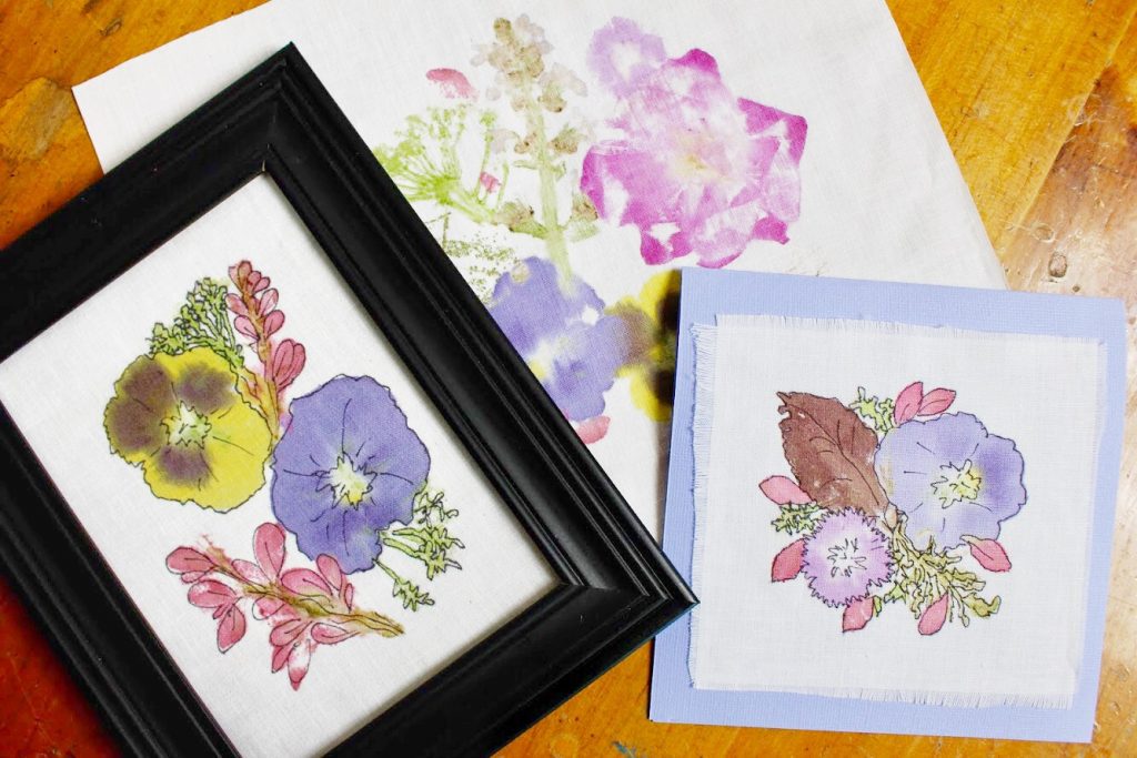 A framed flower print, a card with a flower print and a bright hammered fabric print.