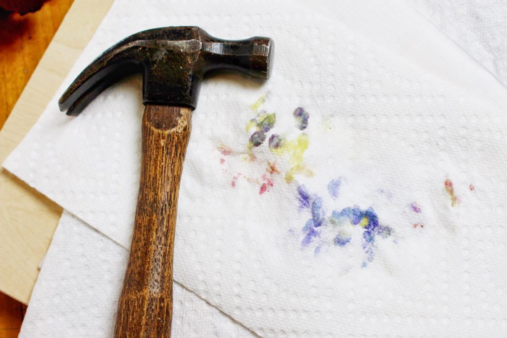 A hammer with layers of paper towels over flowers.