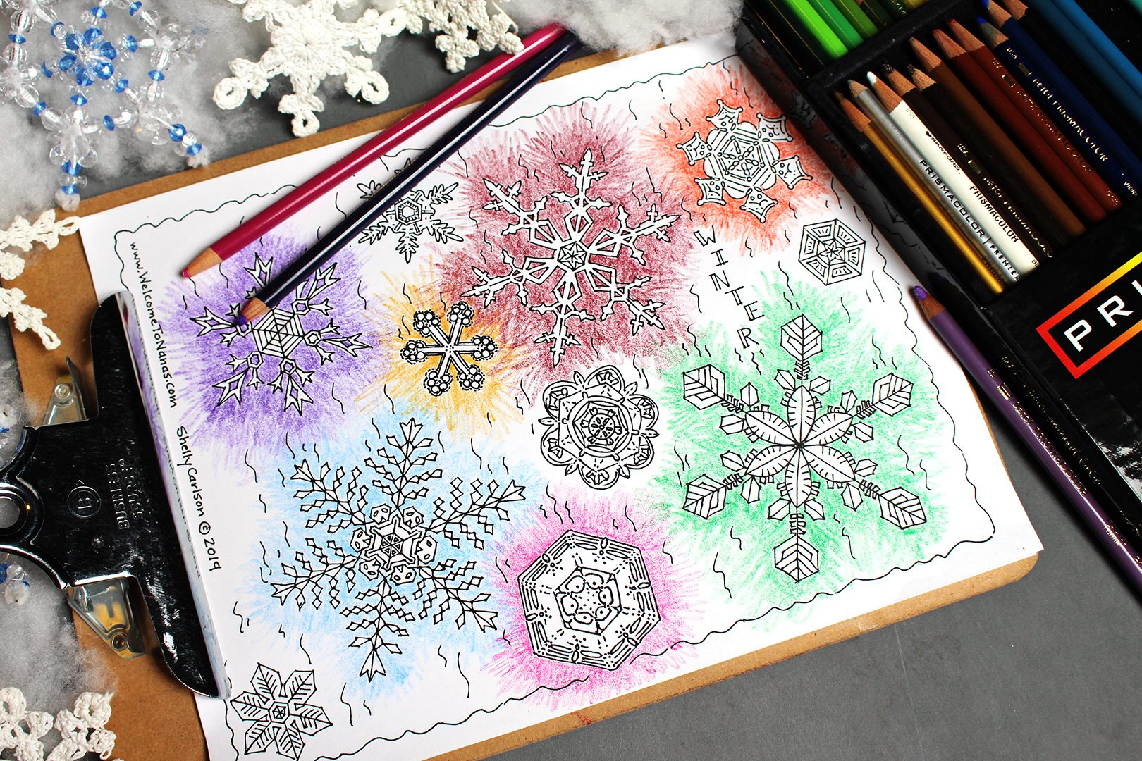 Coloring red, orange, green, and purple snowflakes with a purple colored pencil.