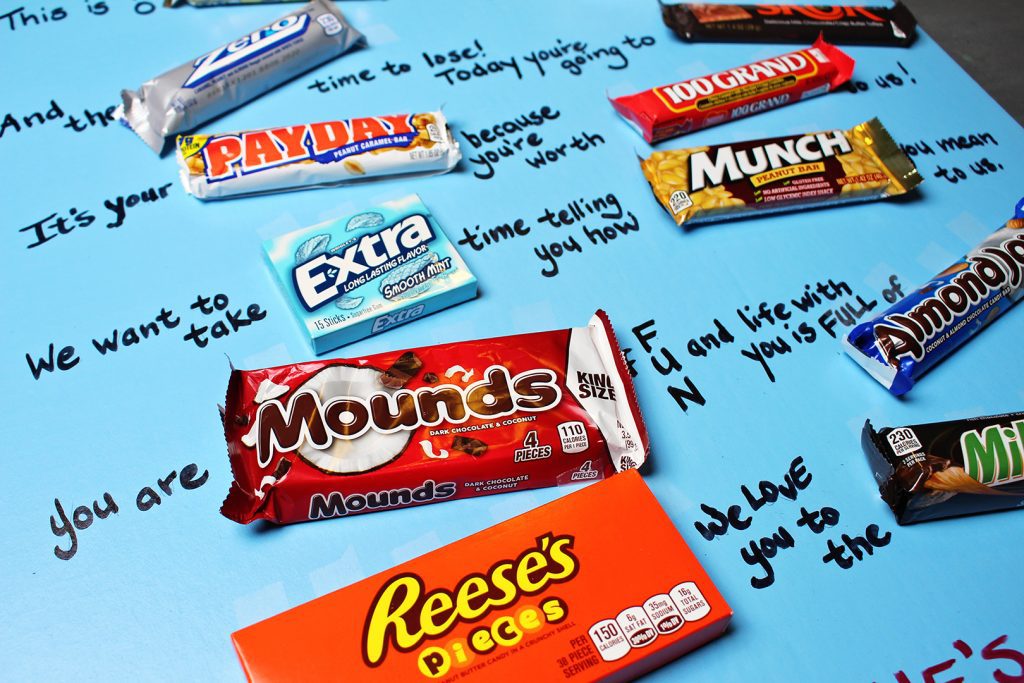 Assorted candy bars layed out on a poster board as a Valentines card.