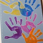 Colorful children's handprints painted on a canvas.