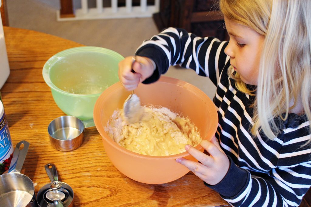 A child mixing up donut batter.