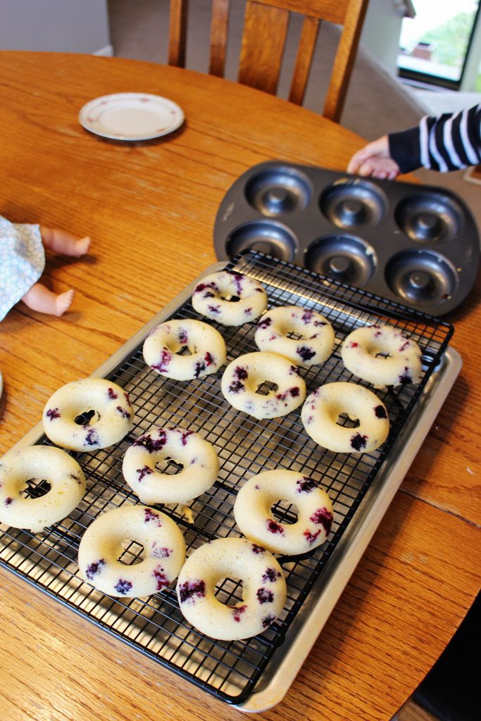 Lemon blueberry donuts cooling on a cooling rack.