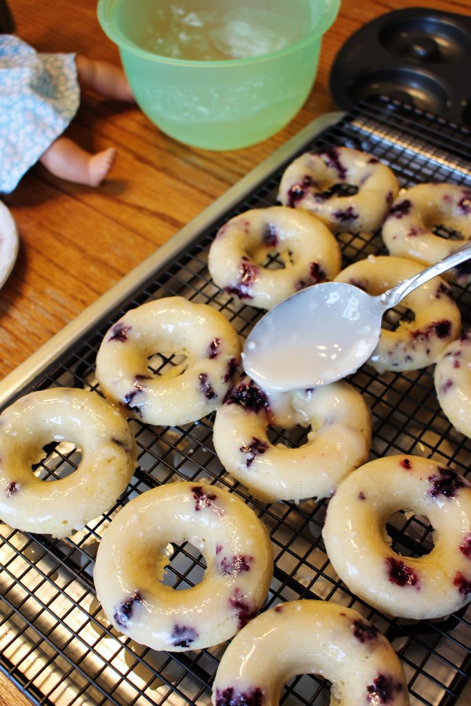 Drizzling glaze on the lemon blueberry donuts.