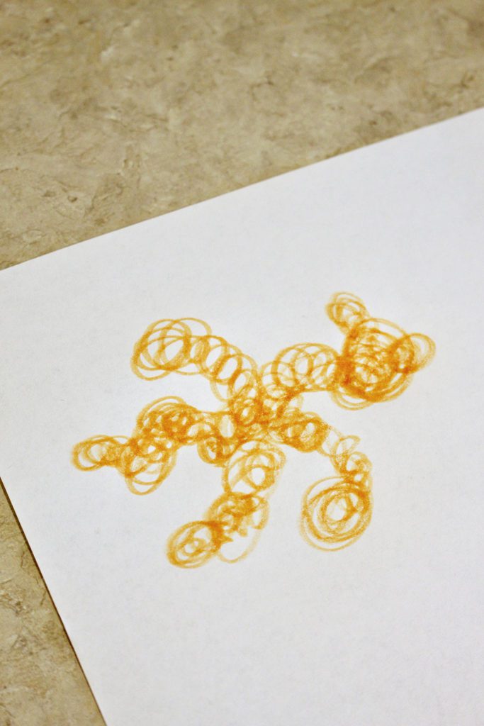 Orange scribbles on a piece of paper
