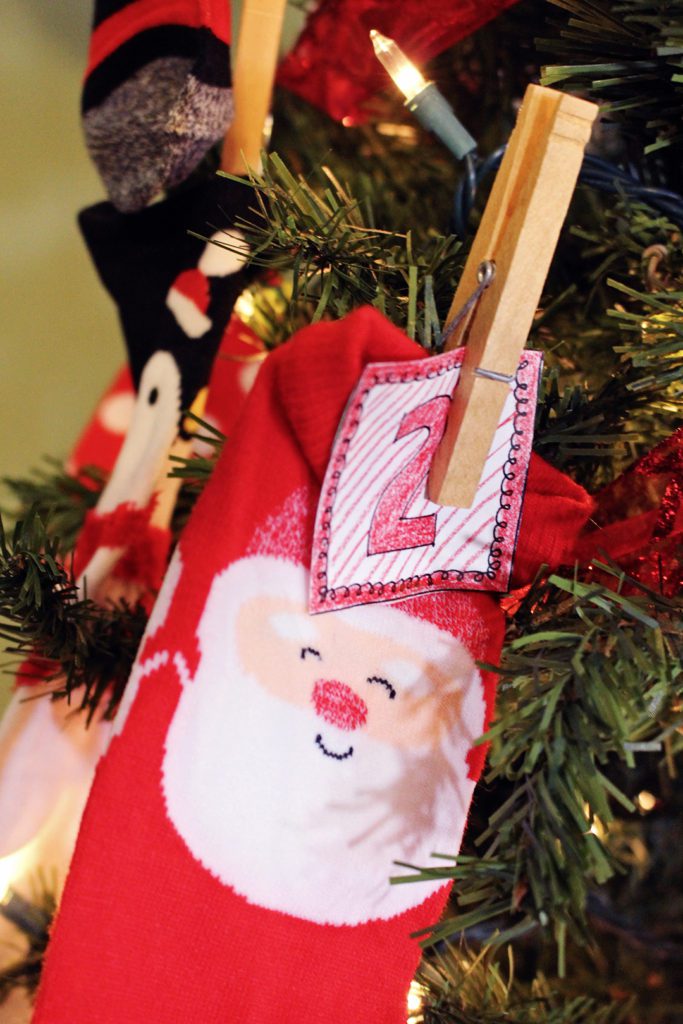 Santa sock secured to a Christmas tree branch with an advent calendar number attached