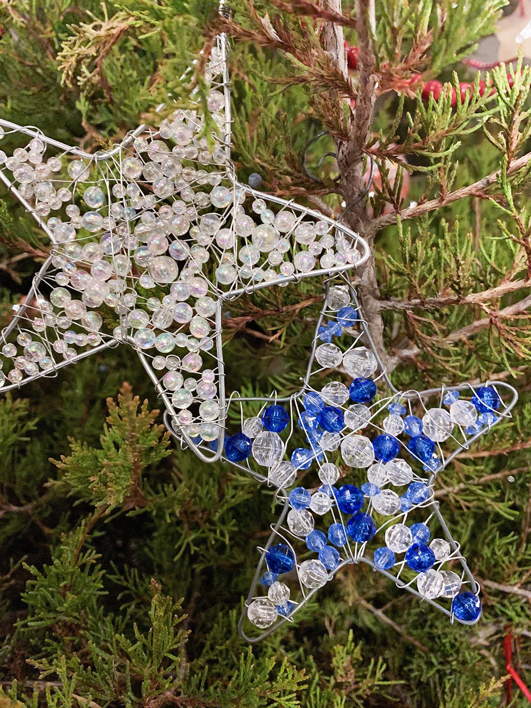 Sparkling Wire and Bead Ornament Stars hanging on a Christmas tree.