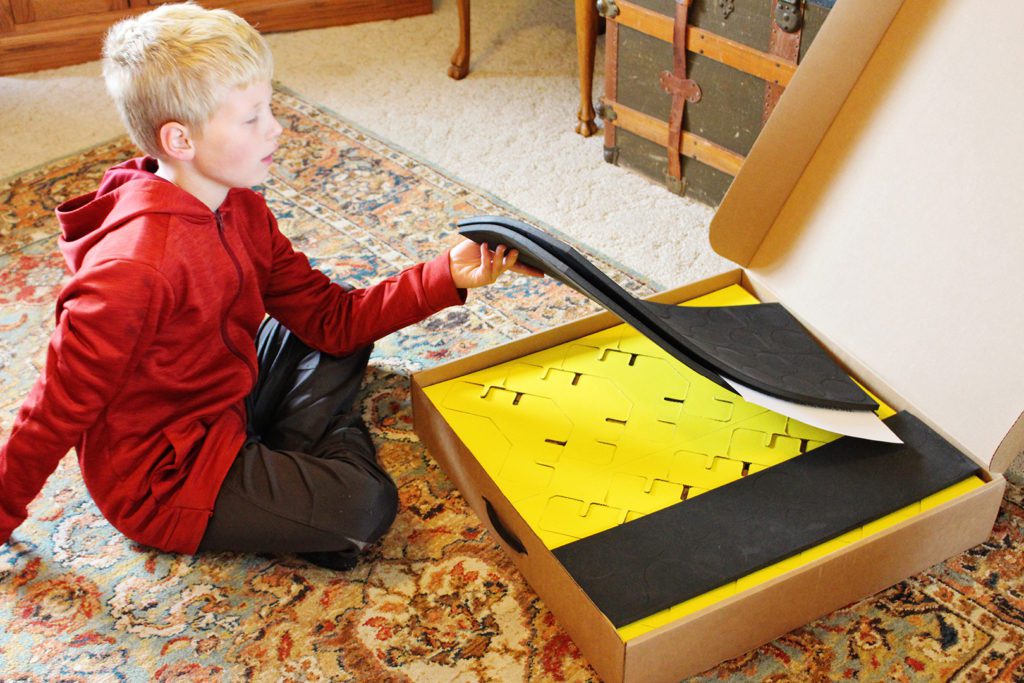A boy opening the Make-A-Fort kit box