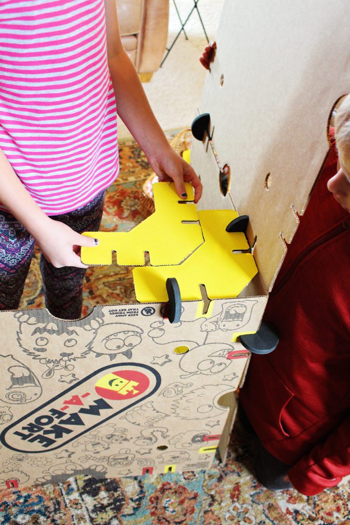A child piecing together the Make-A-Fort Kit