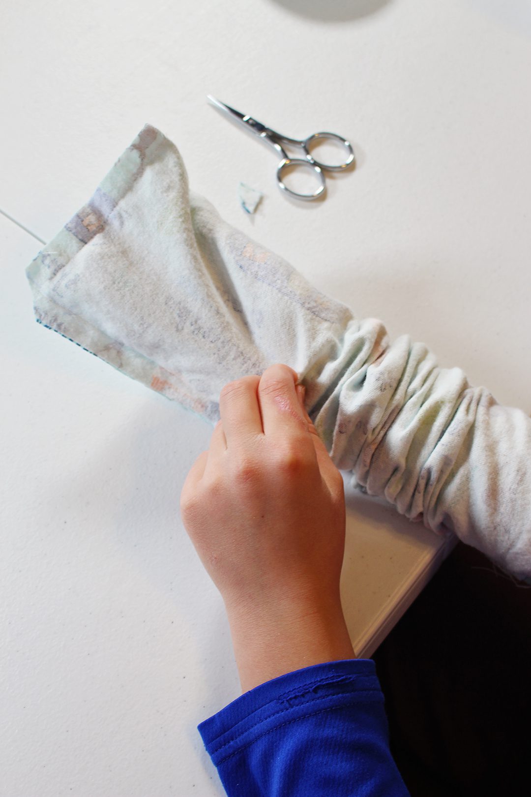 A child turning a sewed bag inside out.