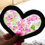 Light shining through a pink and green stained glass Valentine's Day heart card.