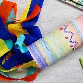 A brightly colored Watercolor Resist Painted Windsock for Kids with streamers.