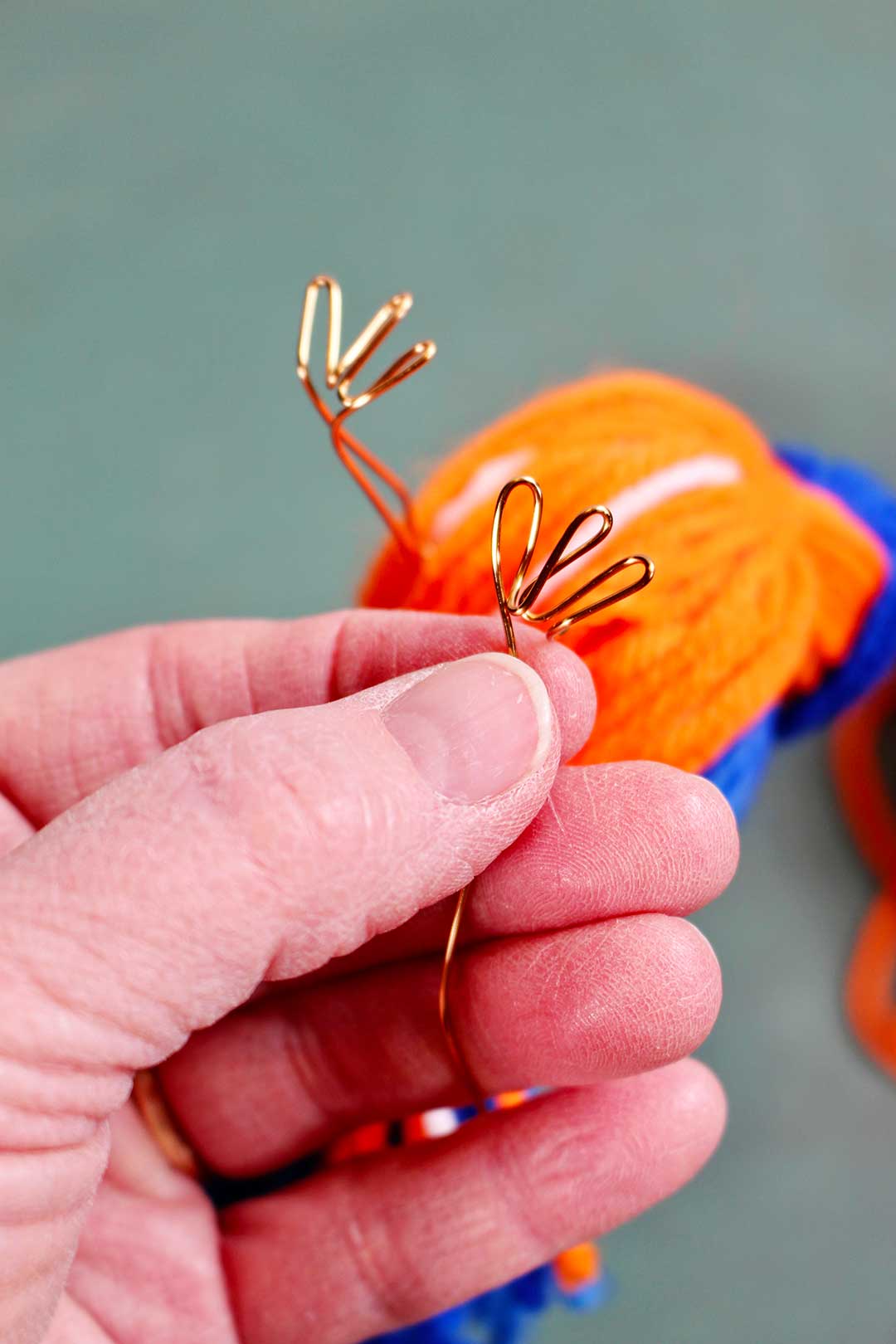 Copper wire bent in three loops to create bird feet.