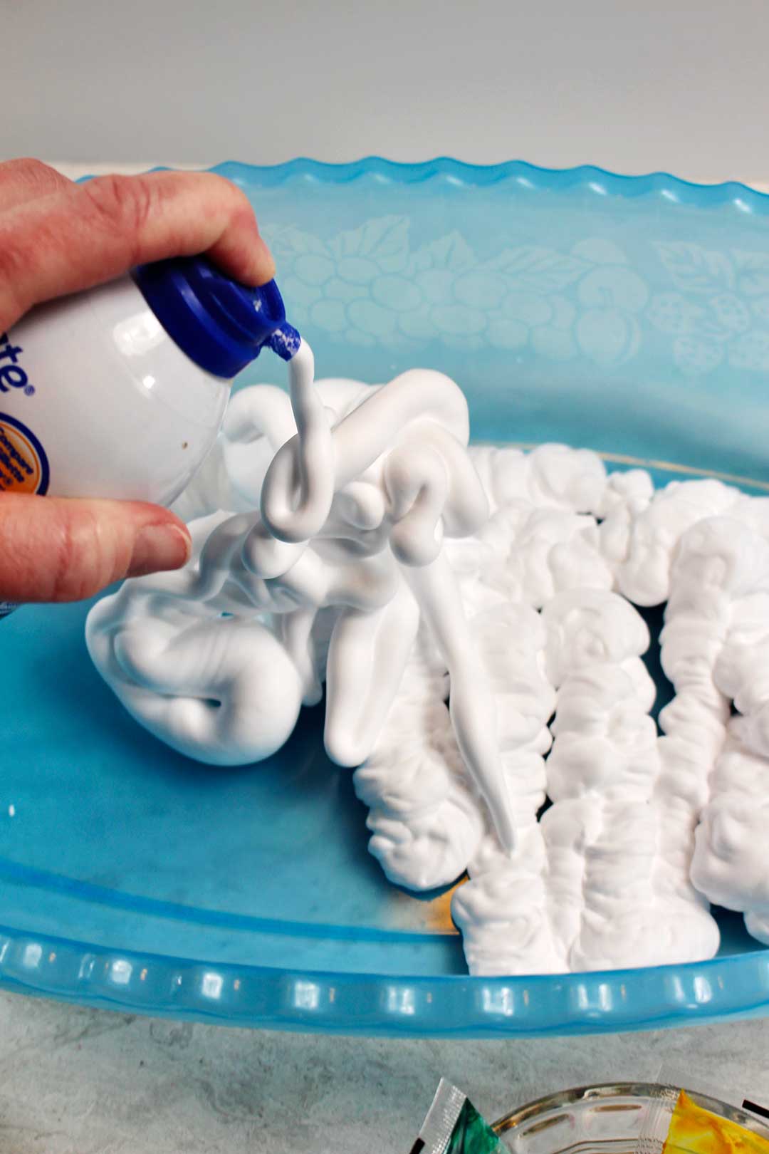 Spraying shaving cream into a plastic tub.