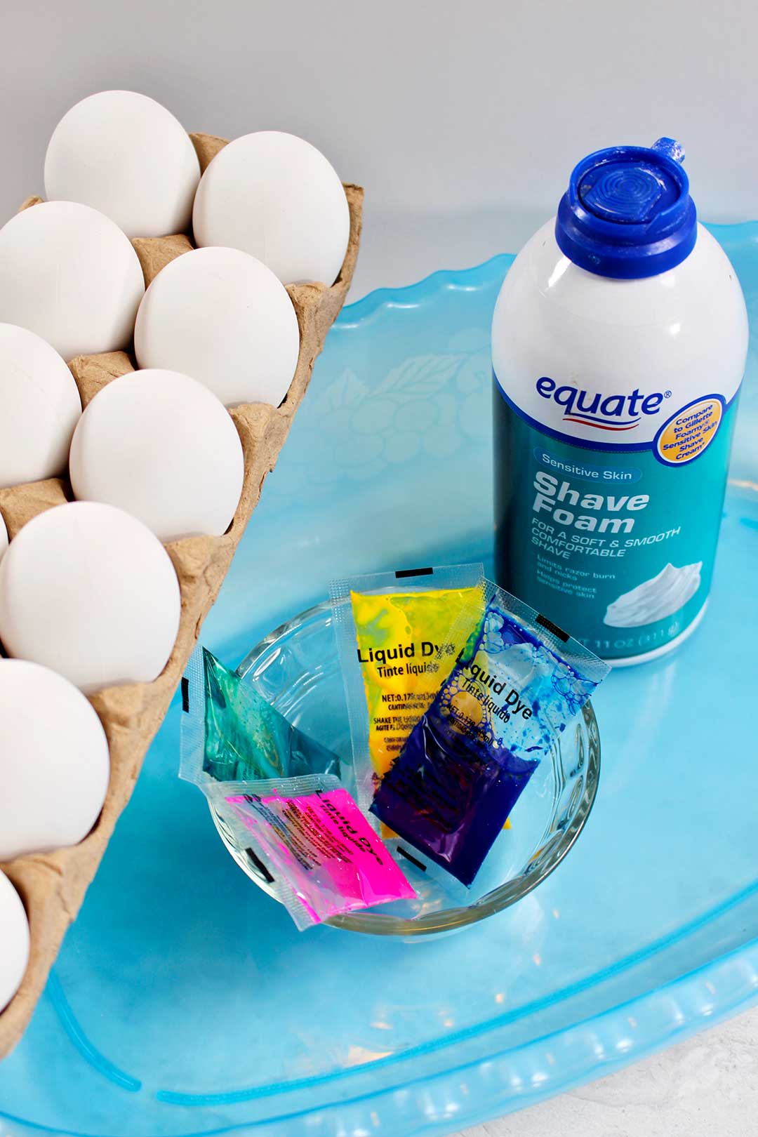 Liquid dye, shaving foam, a blue plastic tub, and a dozen eggs.