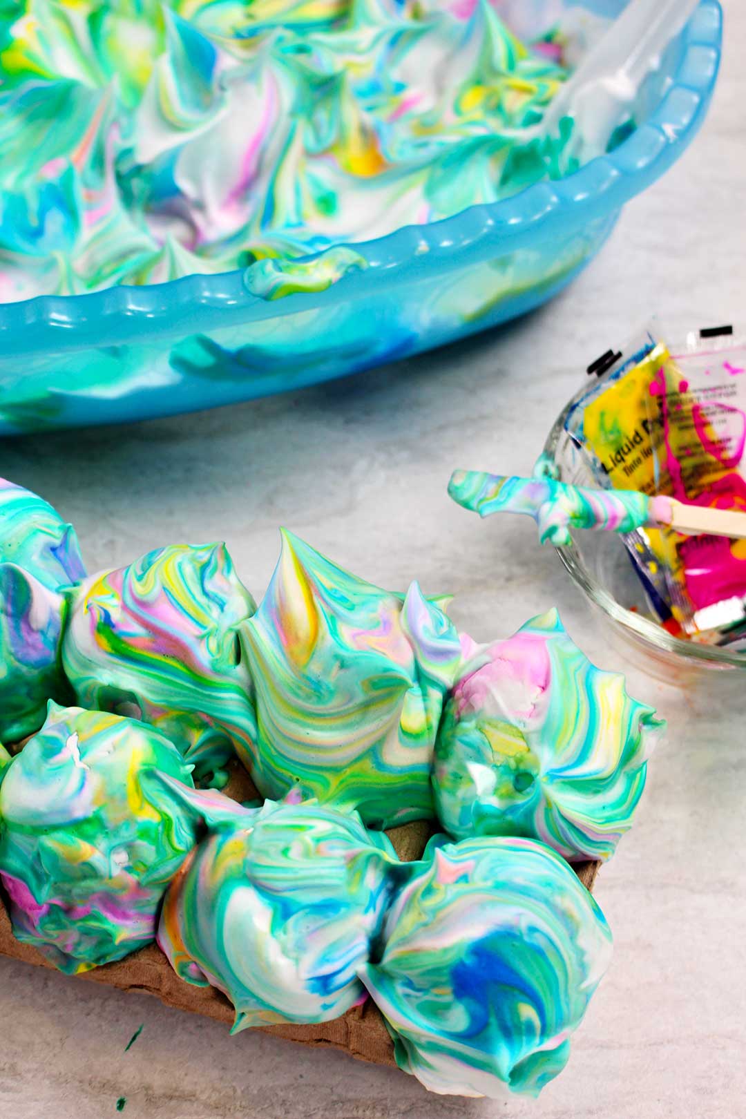 Eggs covered in yellow, green, blue, and pink swirled shaving cream.