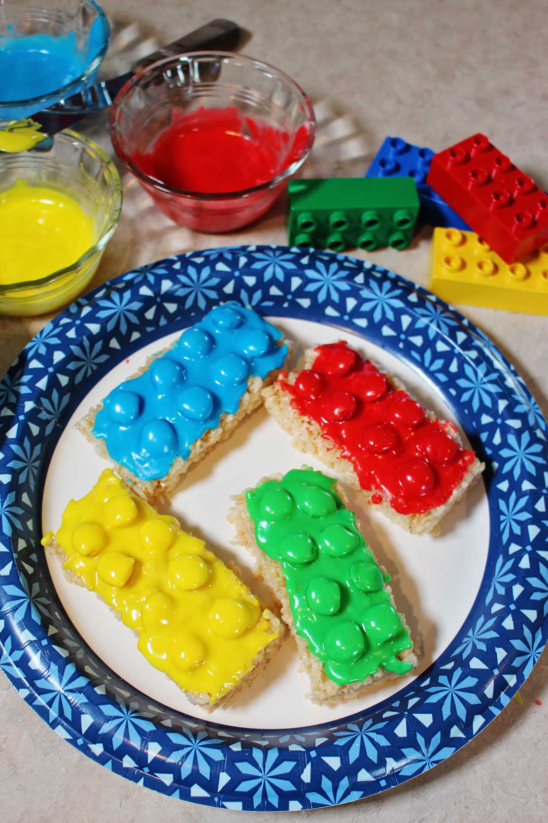 A plate of red, yellow, green, and blue LEGO brick cookies!