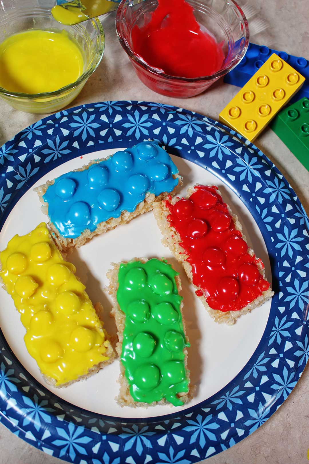 A plate of red, yellow, green, and blue LEGO brick cookies!