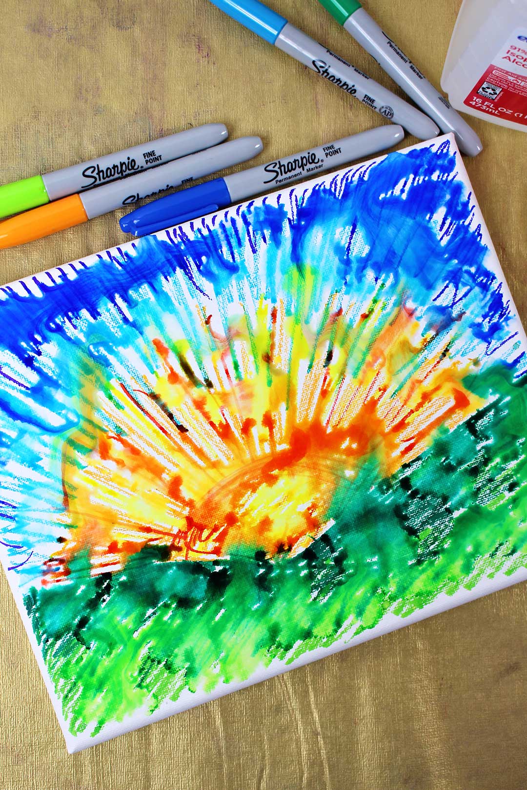 A sunset picture drawn with sharpies on canvas, starting to blur from drips of alcohol.
