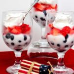 Red white and blue fruit parfaits with blueberries, strawberries, and whipped cream.