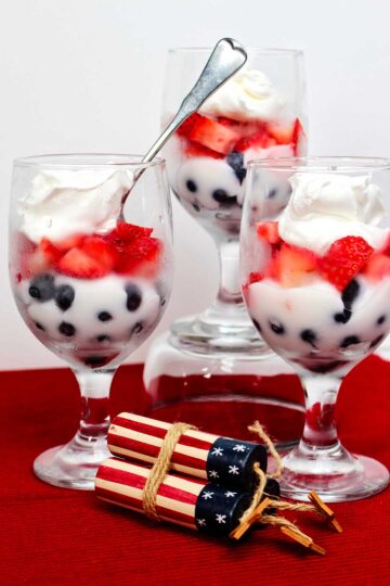 Red white and blue fruit parfaits with blueberries, strawberries, and whipped cream.