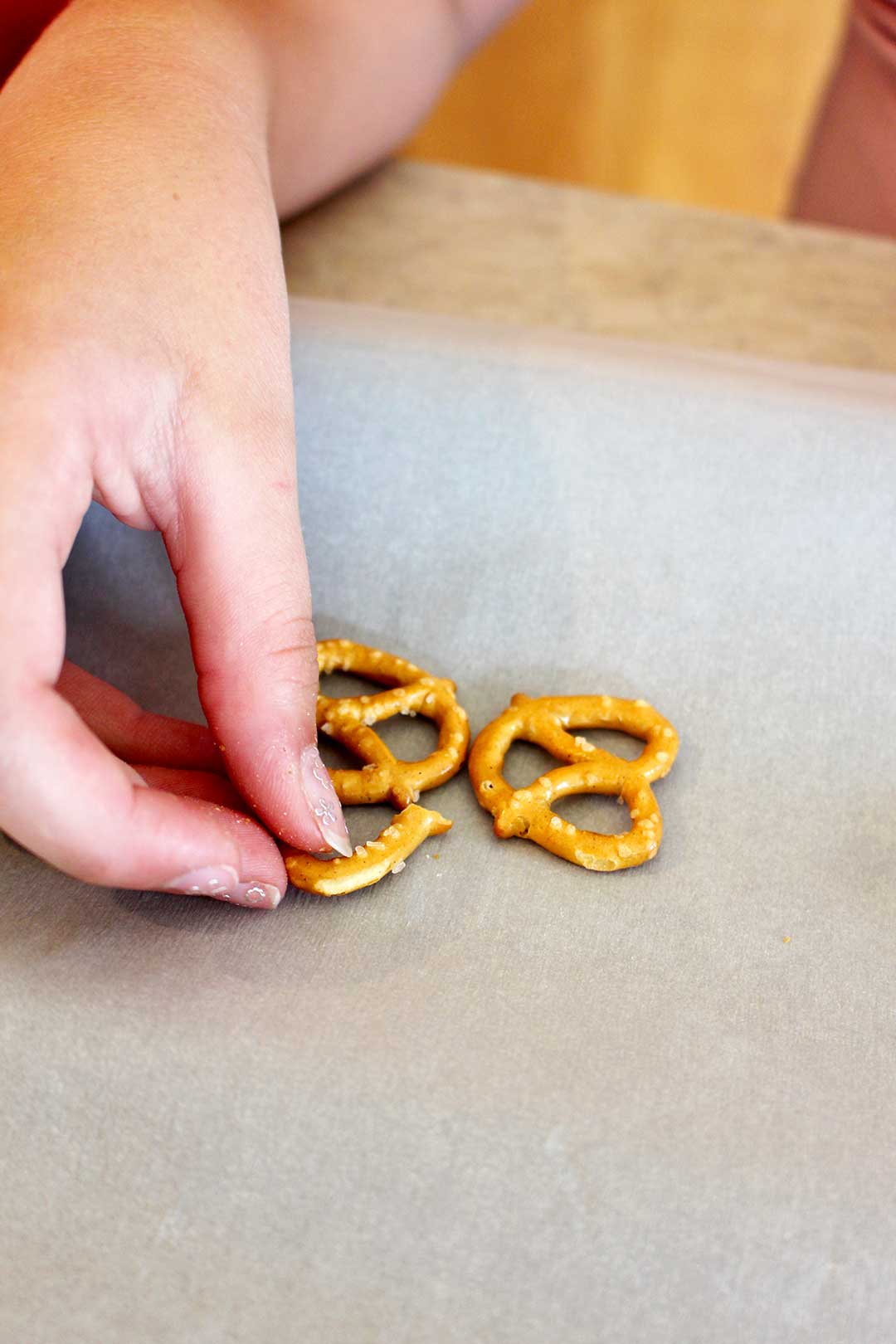 A child arranging pretzels in the shape of a butterfly.
