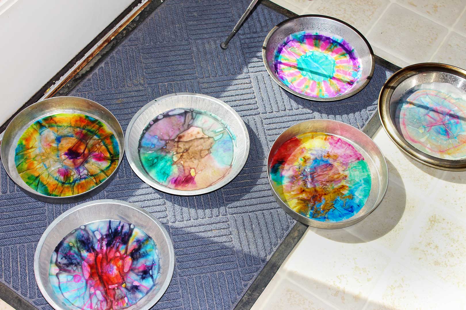 Colorful coffee filters drying after being sprayed with water to bleed the colors.