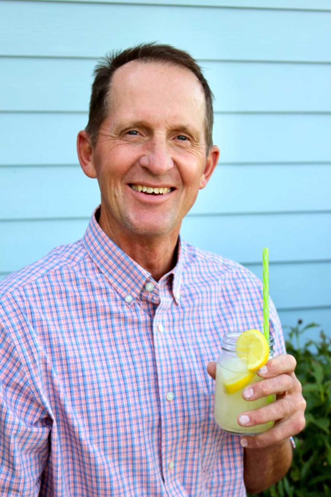 A man holding a glass of lemonade outdoors