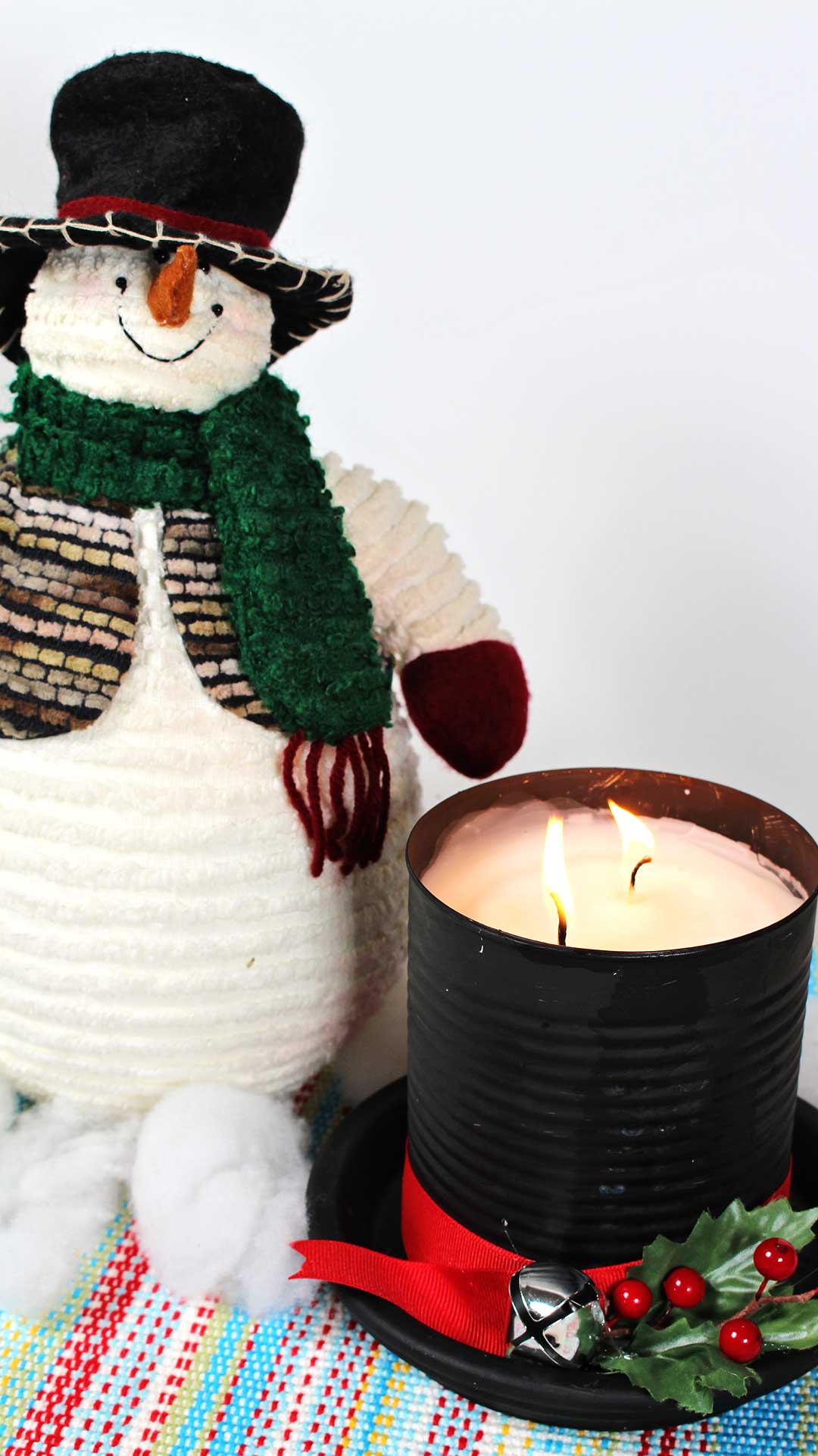 Stuffed snowman next to DIY Snowman Hat Candle