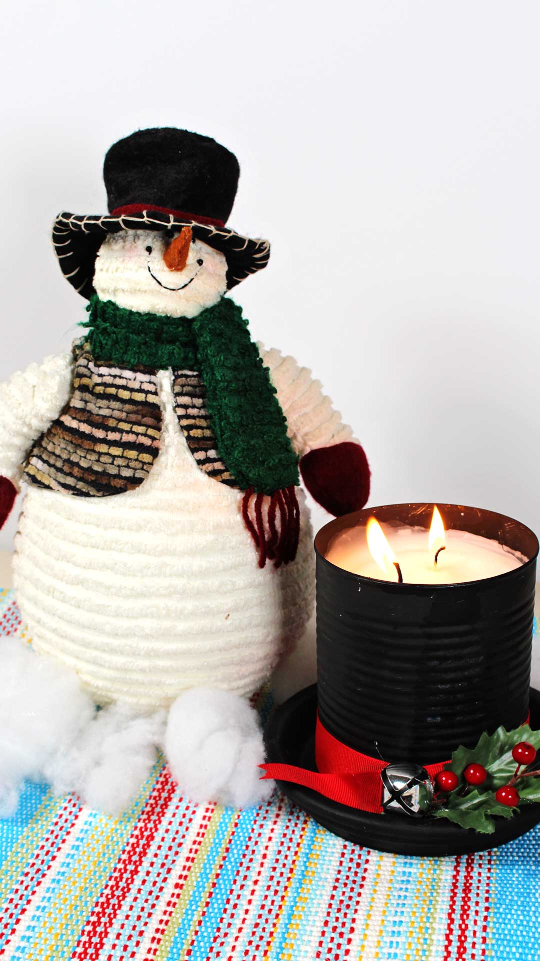 Lit DIY Frosty The Snowman Candle next to stuffed snowman.