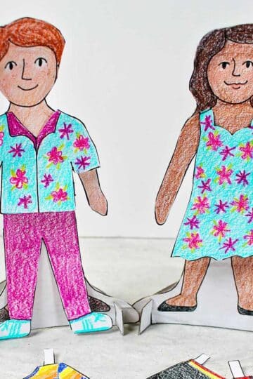 Boy and girl paper dolls, colored and dressed on their bases. Colored pencils and other colored clothing options nearby.