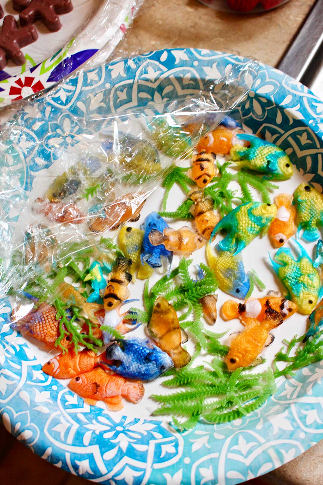 Paper plate with many various plastic tropical fish and sea plants.