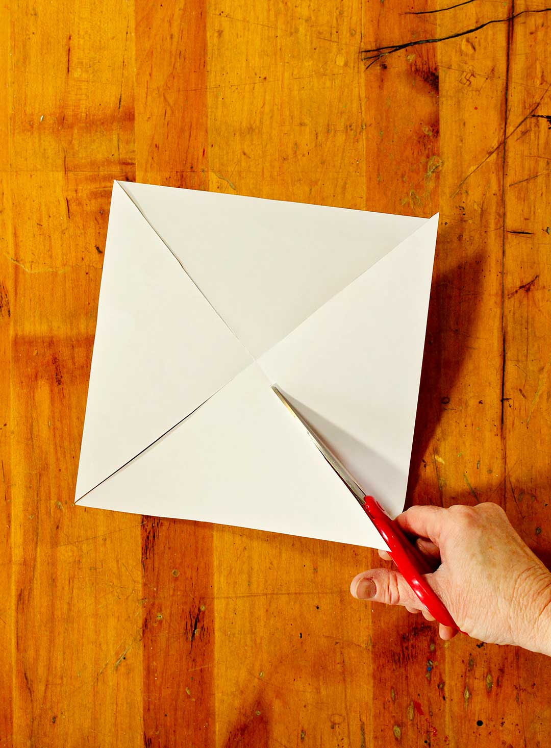 Dos blanc du papier à motif montrant la coupe de quatre lignes diagonales vers le centre.