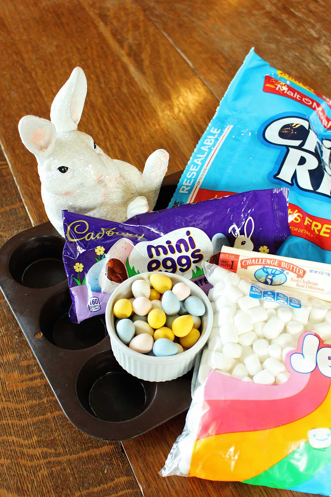 Chocolate Easter Eggs, marshmallows, rice krispies and an easter bunny sitting on a muffin tray.