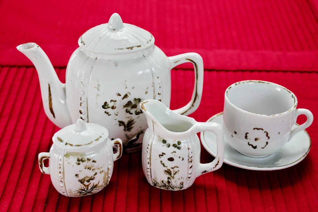 Antique child's tea set with tea pot, cup, saucer, cream pitcher and sugar pot
