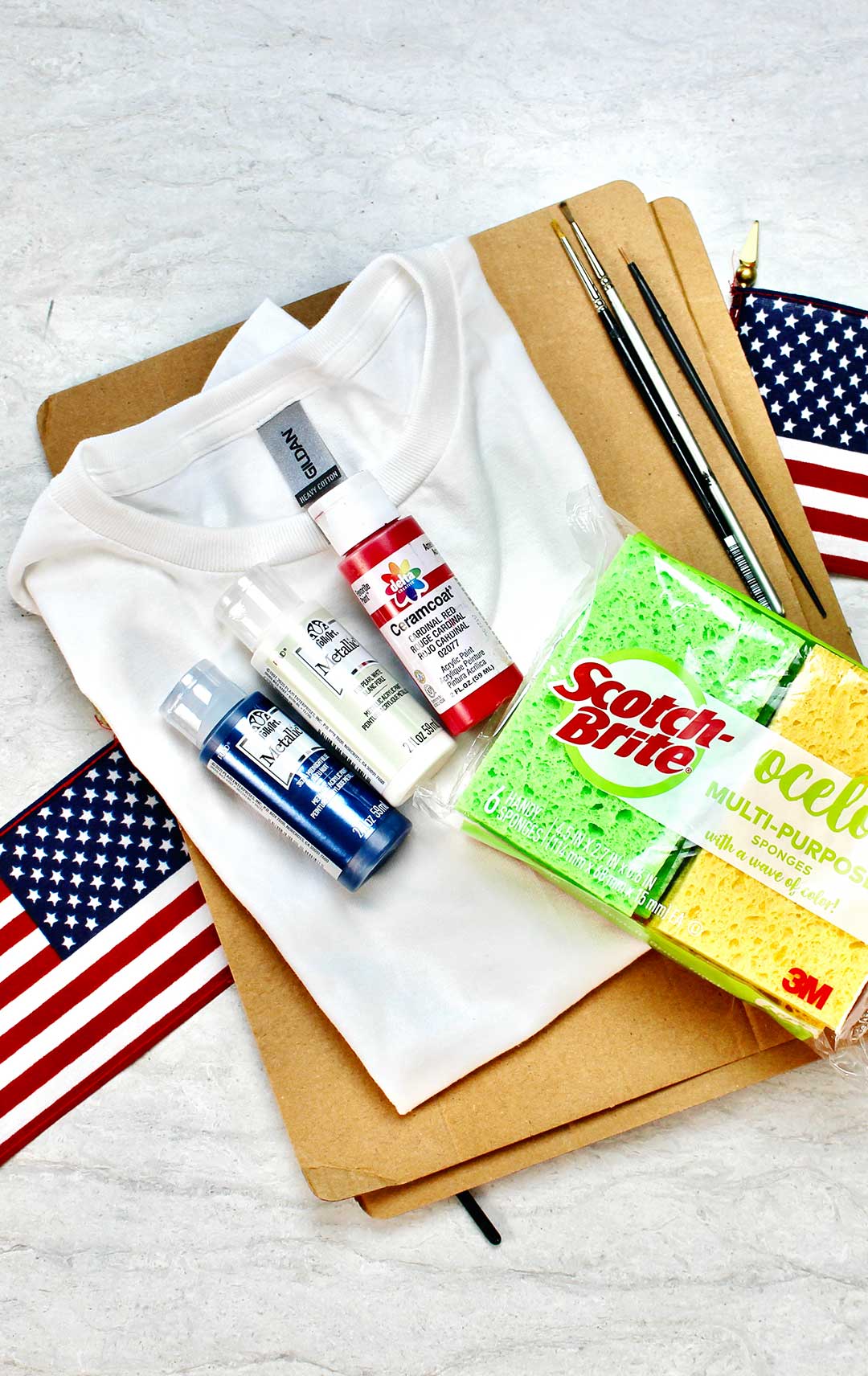 Supplies for 4th of July shirts. Green and yellow sponges, cardboard, paintbrushes, acrylic paints and a white t-shirt.