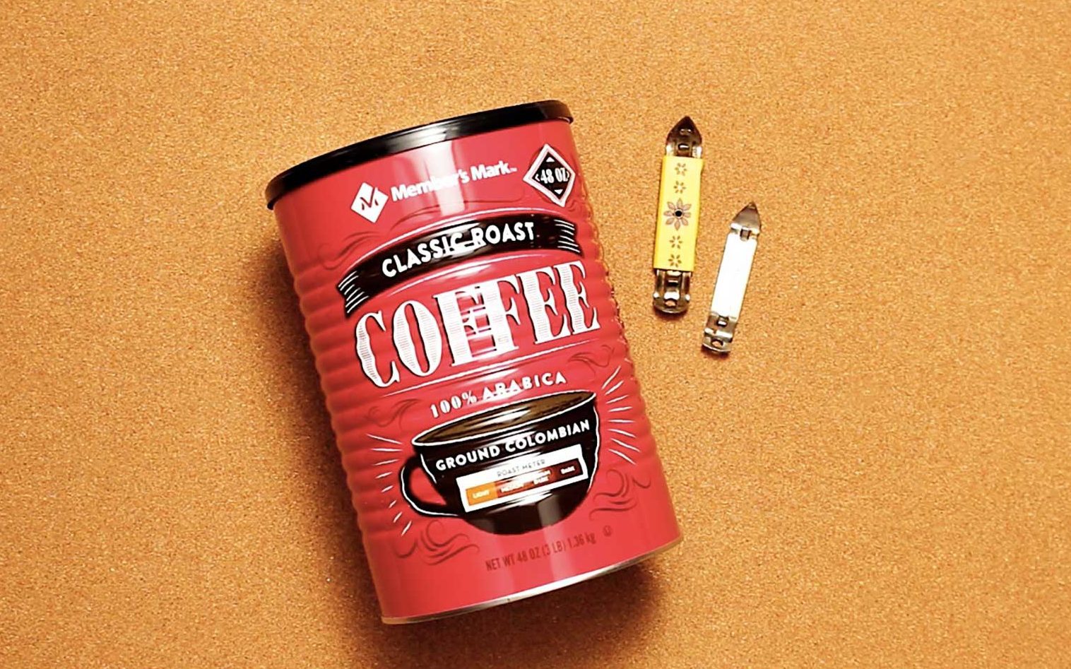 Two small can openers and a coffee can resting on cork colored background.