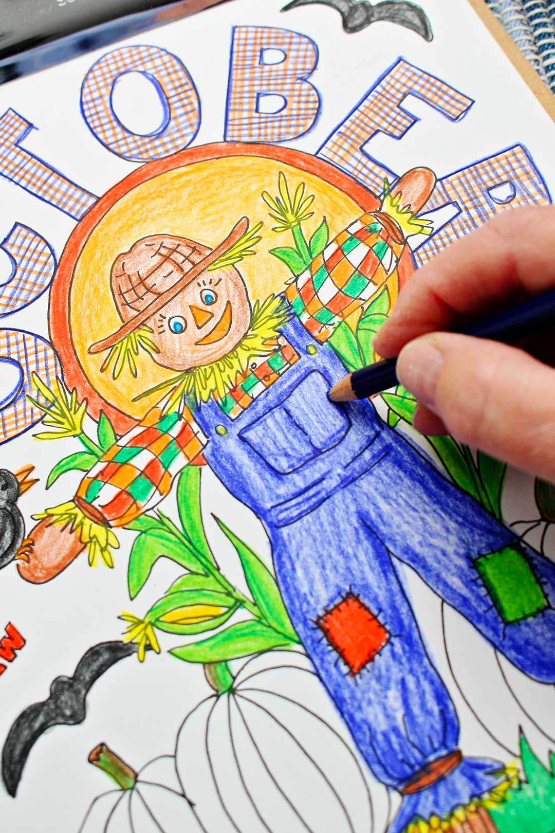 Hand coloring detail in scarecrow's overalls in October coloring page.