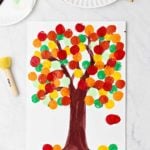 Completed fall tree painting using warm colored paints and some green and light green paint as well.
