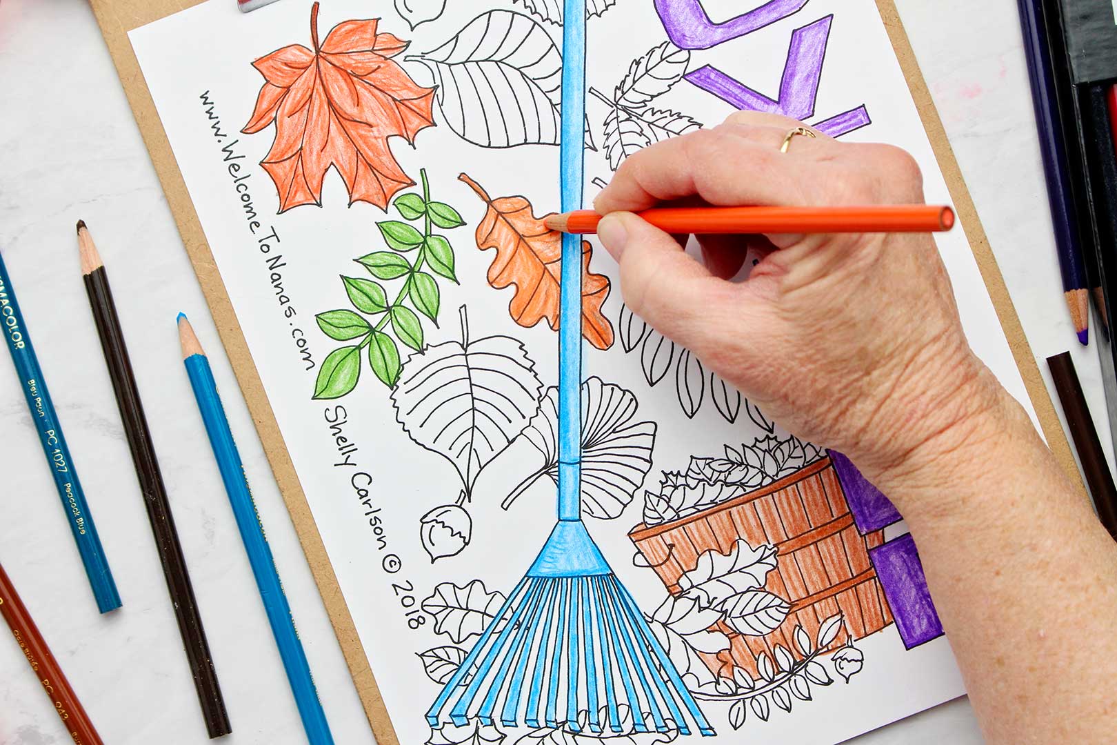 Hand coloring a leaf orange on November coloring page.