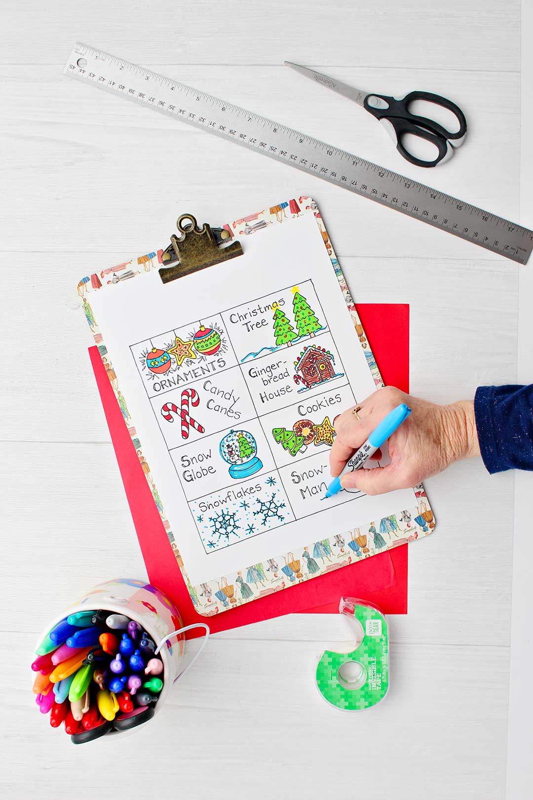 Printout of different Christmas cards you can color and use for the headbands game as well as permanent markers, a ruler, scissors, tape and red paper.