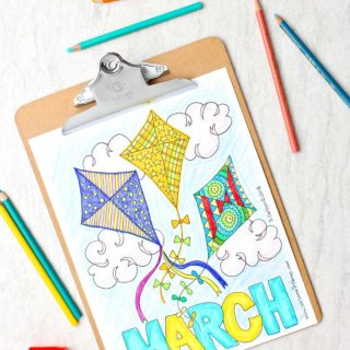 Completed March coloring page. Three kites with different patterns colorfully filled in with colored pencils near by.