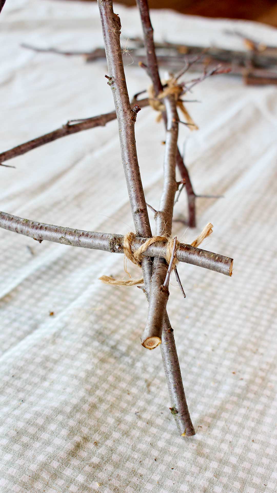 Close up view of the joint where the twigs are tied together with twine.